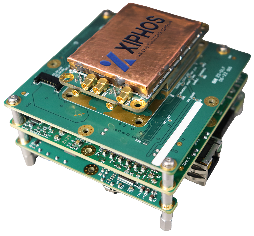 A stack of three green circuit boards, featuring a copper-colored Xiphos branded component on top and visible connectors.